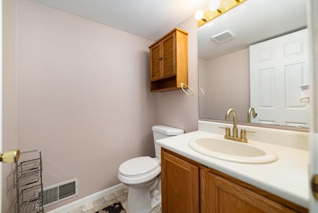 bathroom with visible vents, baseboards, toilet, and vanity