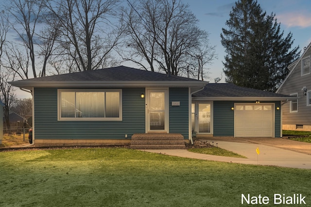 view of front of property featuring a garage, roof with shingles, concrete driveway, and a front yard