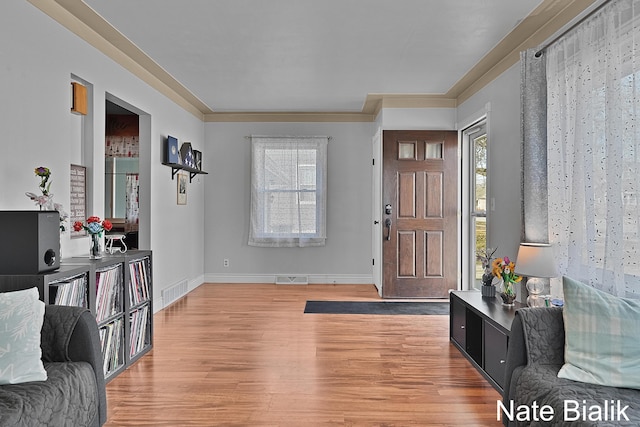 foyer entrance featuring light wood-style flooring, visible vents, and a wealth of natural light