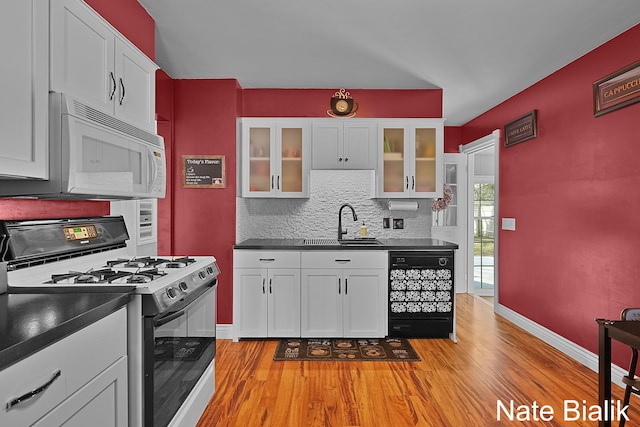 kitchen with range with gas cooktop, dark countertops, black dishwasher, and white microwave