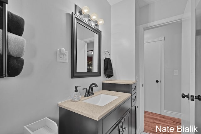 bathroom with wood finished floors and vanity