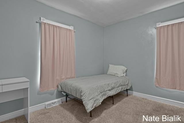 carpeted bedroom with visible vents and baseboards