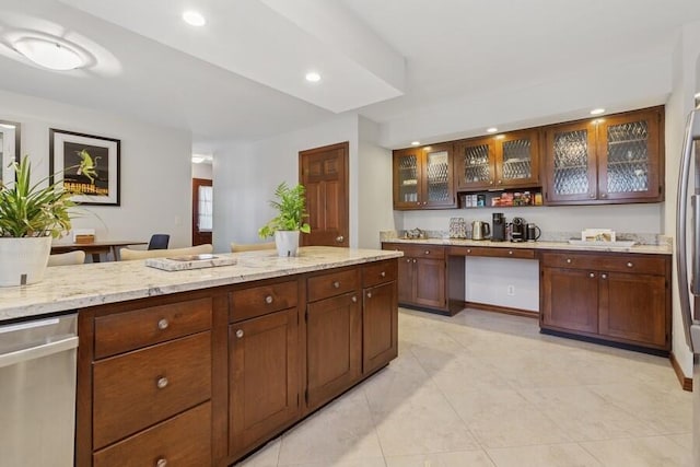 kitchen with recessed lighting, glass insert cabinets, light stone countertops, and stainless steel dishwasher