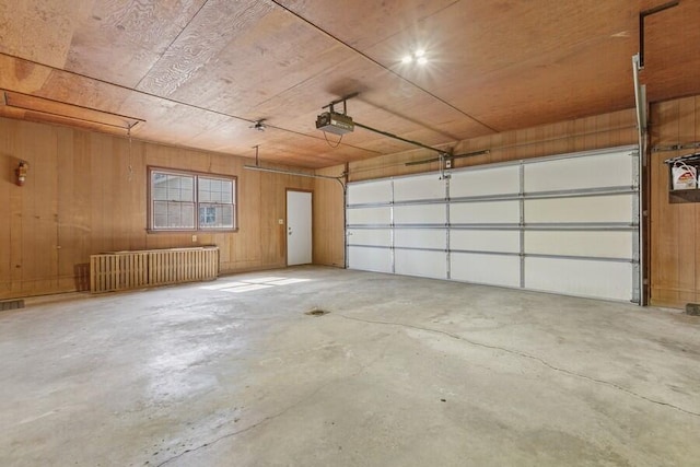 garage featuring wood walls and a garage door opener