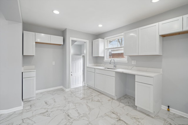 kitchen with recessed lighting, baseboards, and a sink