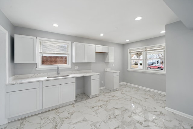 kitchen with white cabinetry, recessed lighting, baseboards, and a sink