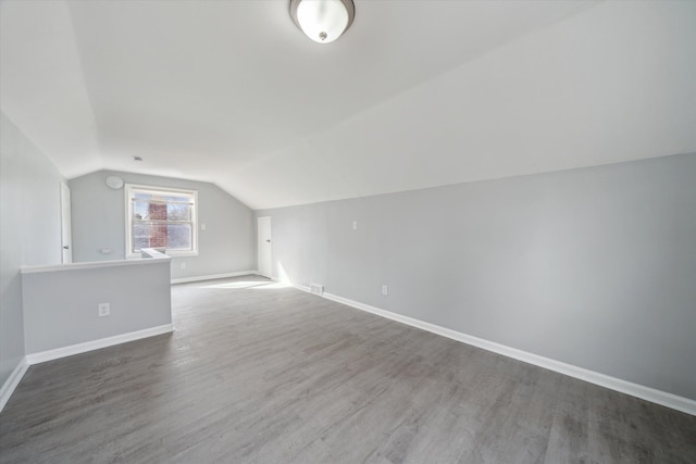 bonus room featuring baseboards, lofted ceiling, and wood finished floors