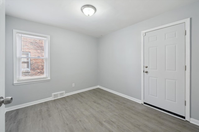 empty room with visible vents, baseboards, and wood finished floors