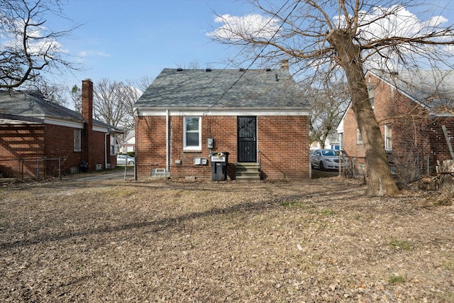 rear view of house featuring brick siding and entry steps