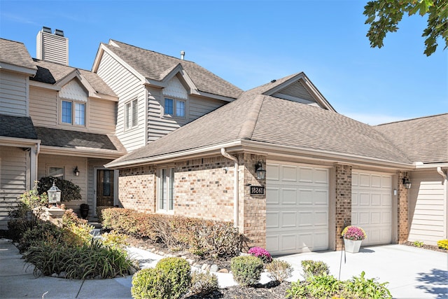 view of home's exterior with brick siding, roof with shingles, concrete driveway, and an attached garage