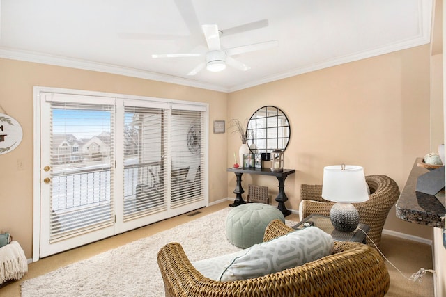 sitting room with crown molding, a ceiling fan, baseboards, and carpet floors