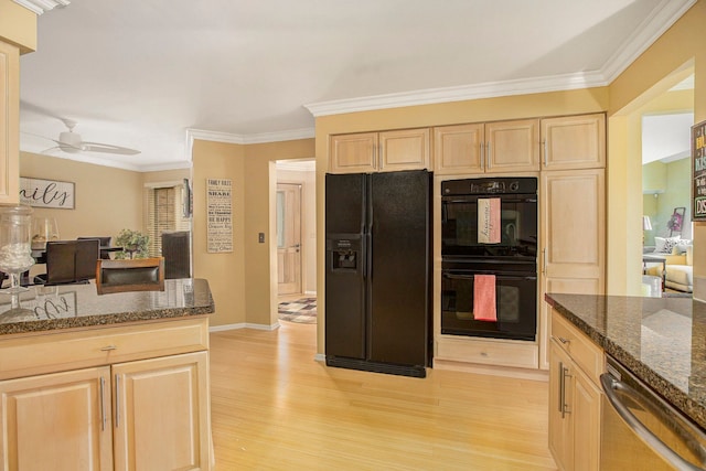 kitchen featuring dark stone counters, black appliances, light brown cabinets, and light wood finished floors