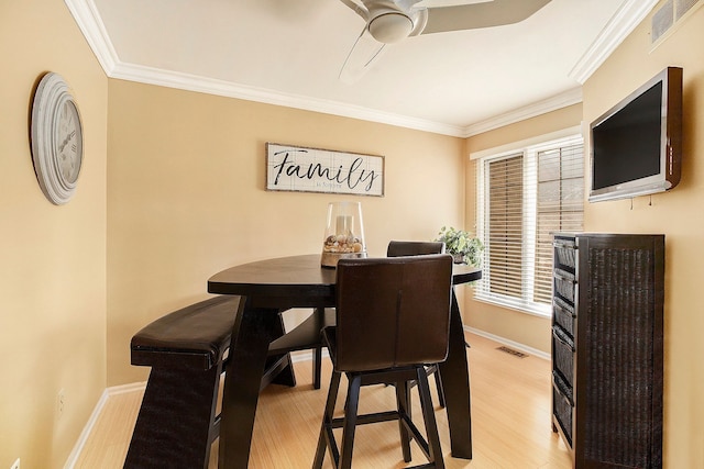 dining area with visible vents, a ceiling fan, and ornamental molding