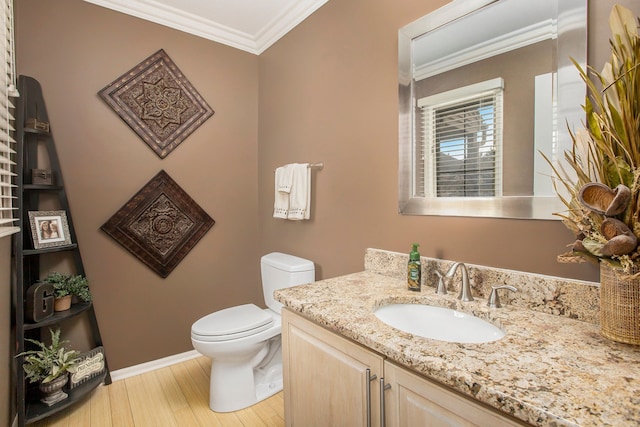 half bathroom featuring crown molding, baseboards, toilet, wood finished floors, and vanity