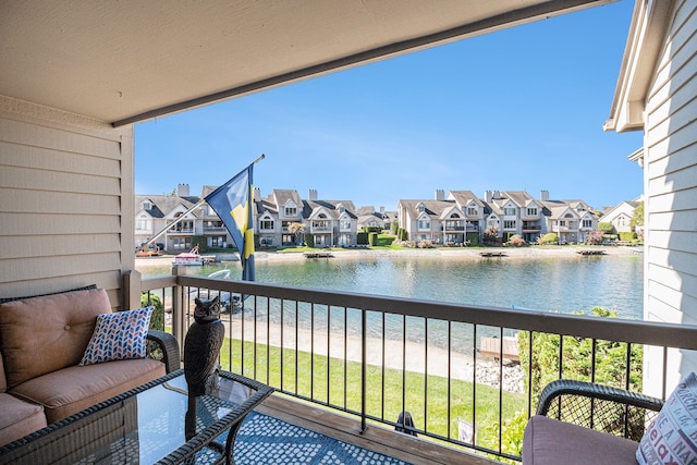 balcony featuring a residential view and a water view