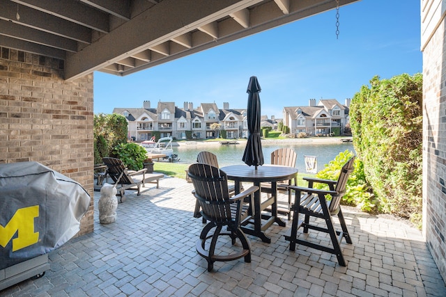 view of patio / terrace featuring outdoor dining area, a residential view, and a water view