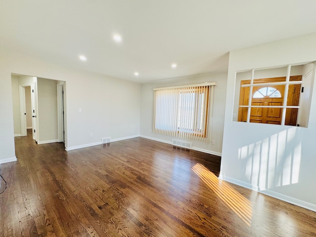 unfurnished living room with recessed lighting, visible vents, baseboards, and wood finished floors