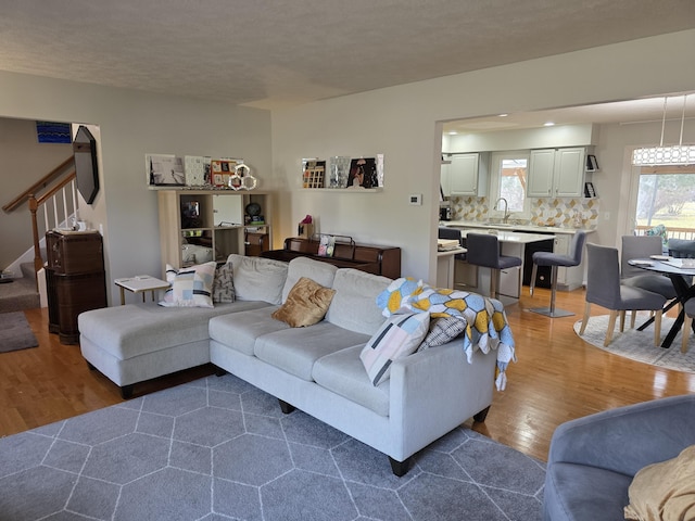 living area with stairway and wood finished floors