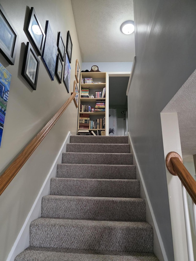 stairway featuring a textured ceiling