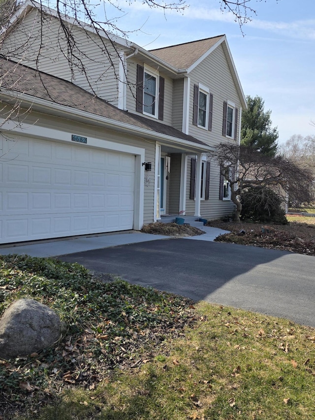 traditional-style house with an attached garage and driveway