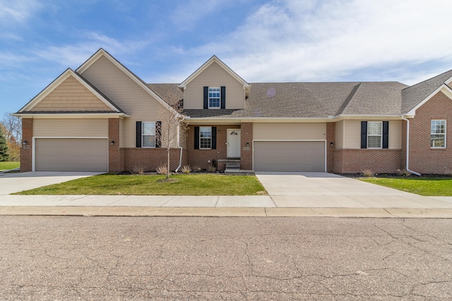 view of front of house featuring a garage, driveway, brick siding, and a front lawn