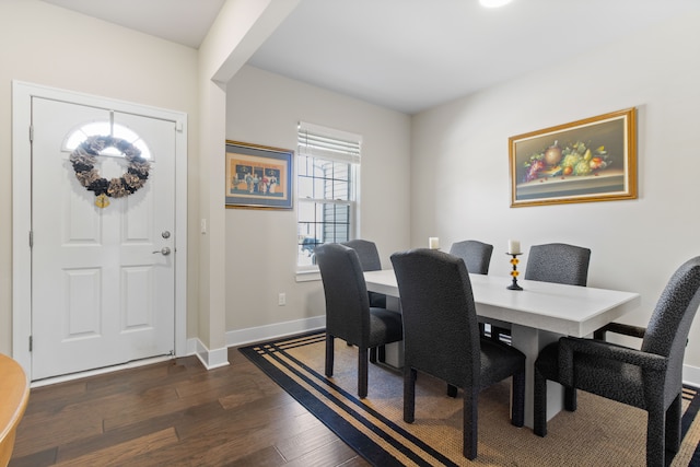 dining space featuring dark wood-type flooring and baseboards