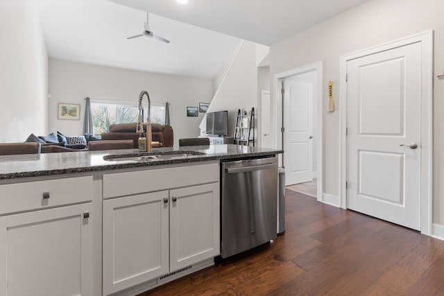 kitchen featuring a sink, open floor plan, dark wood finished floors, dark stone counters, and dishwasher