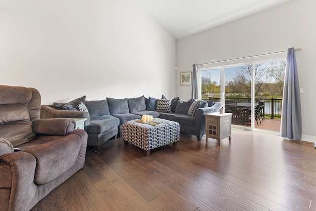 living room featuring a high ceiling and dark wood-style floors