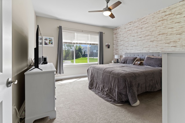 bedroom featuring carpet flooring, a ceiling fan, and an accent wall