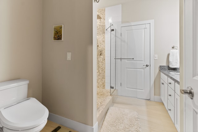 full bath featuring baseboards, toilet, vanity, and a shower stall