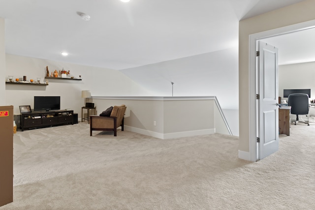 sitting room featuring an upstairs landing, baseboards, and carpet floors