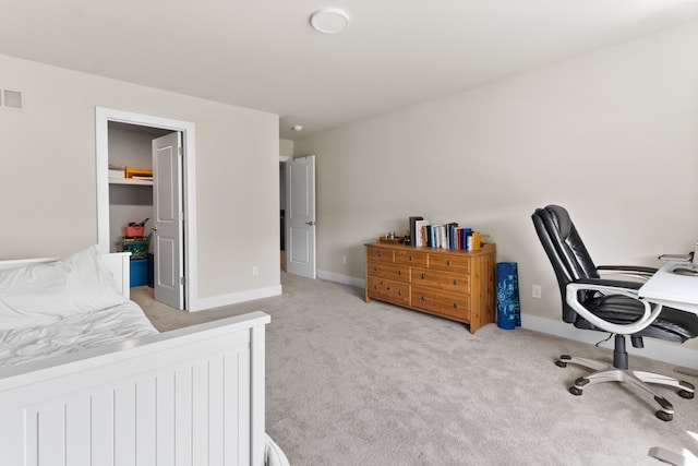 bedroom with a spacious closet, visible vents, baseboards, and carpet