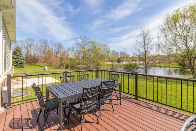 wooden terrace with a water view, a lawn, and outdoor dining space