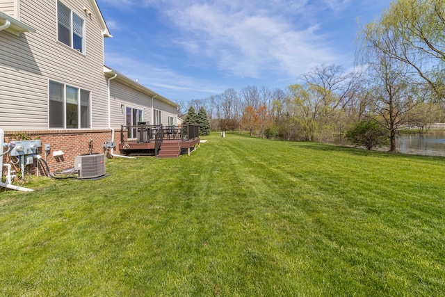 view of yard with central air condition unit and a deck