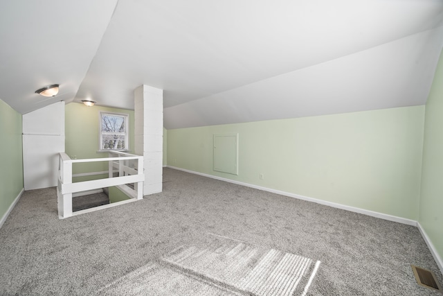 additional living space featuring visible vents, baseboards, carpet flooring, and vaulted ceiling