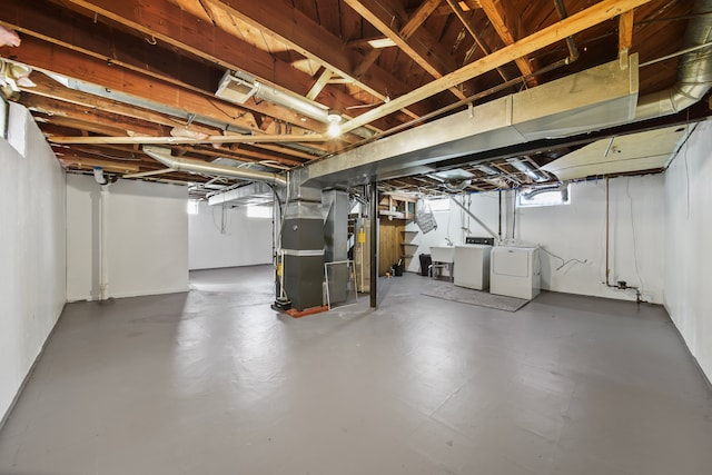 basement featuring gas water heater, heating unit, separate washer and dryer, and a sink