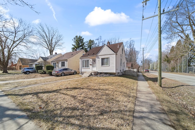 bungalow-style home featuring fence, entry steps, a chimney, driveway, and a gate