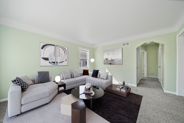 living room with arched walkways, visible vents, baseboards, and carpet floors