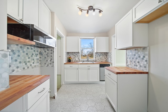 kitchen featuring backsplash, wooden counters, dishwasher, white cabinets, and a sink