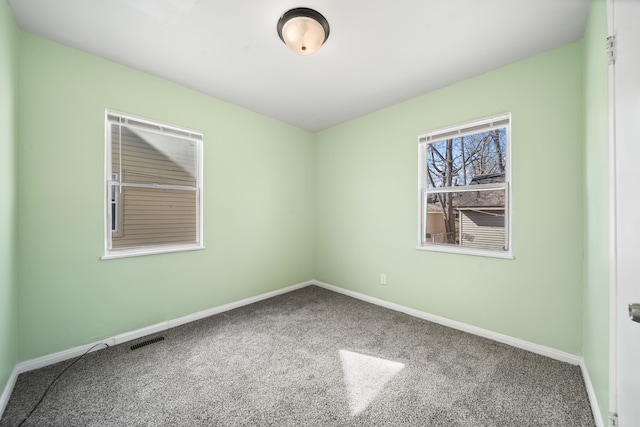 unfurnished room with baseboards, visible vents, and carpet floors