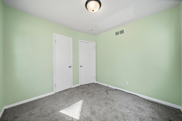 unfurnished bedroom featuring visible vents, baseboards, and carpet