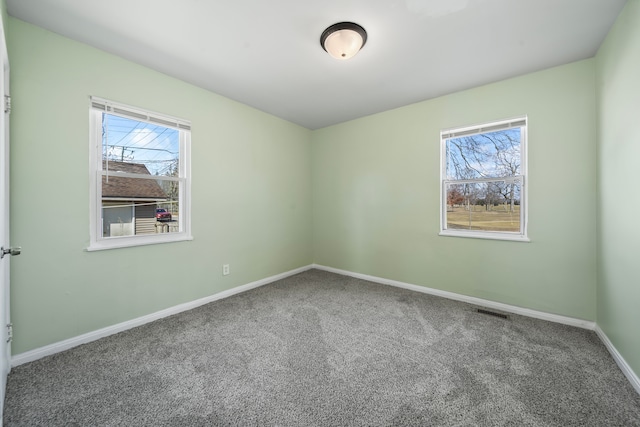 unfurnished room with visible vents, baseboards, and carpet