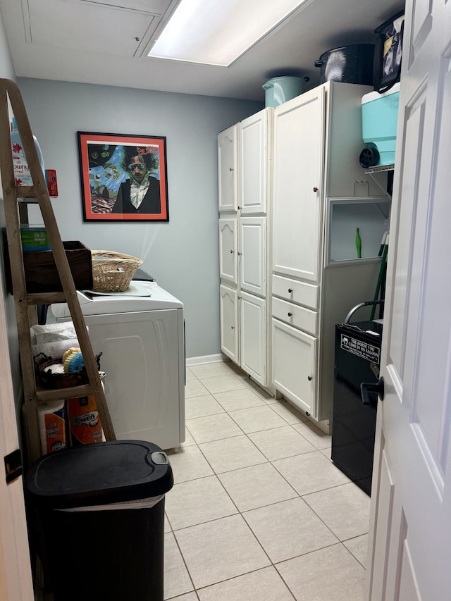 laundry room with cabinet space, light tile patterned flooring, and washer / clothes dryer