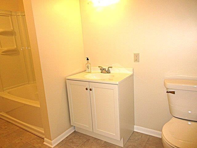 bathroom featuring vanity, toilet, baseboards, and shower / bathtub combination