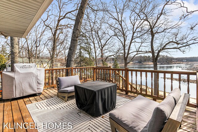 deck featuring outdoor lounge area, a water view, and a grill