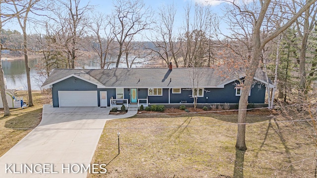 ranch-style home with a water view, a front yard, a garage, and driveway