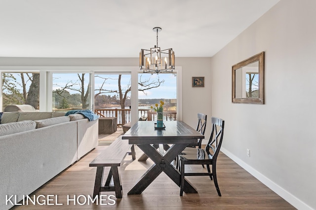 dining room with a chandelier, baseboards, and wood finished floors