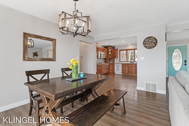 dining area with a chandelier, visible vents, baseboards, and dark wood-style floors