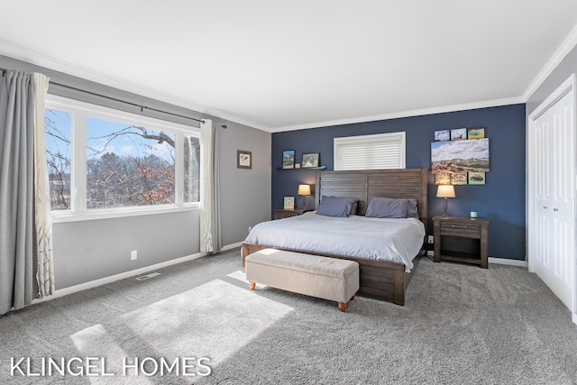 carpeted bedroom with visible vents, baseboards, a closet, and crown molding