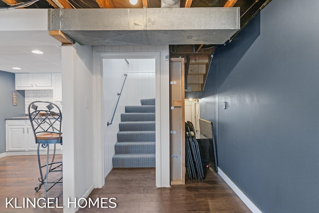 staircase with baseboards and wood finished floors